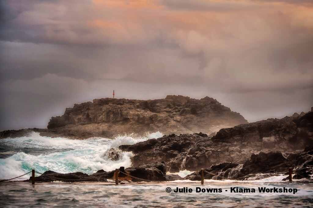 Dramatic seascape with rocky island and marker at Kiama, Australia.